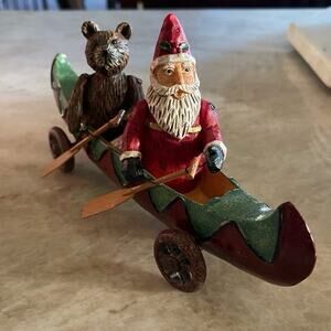 Santa and Bear paddling in a canoe on wheels Christmas decoration